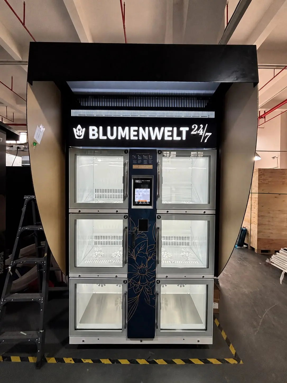 An installed six-compartment machine with a canopy; fascia and centre column are designed around the customer.